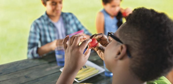 Teens eating at picnic table